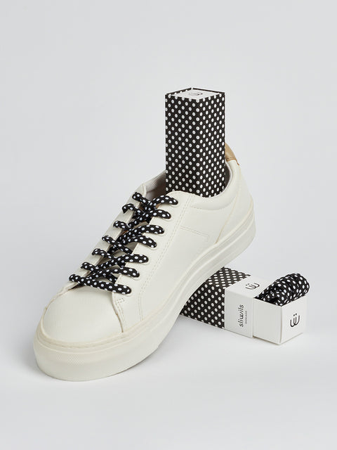 Zapatillas blancas con cordones negros con lunares blancos