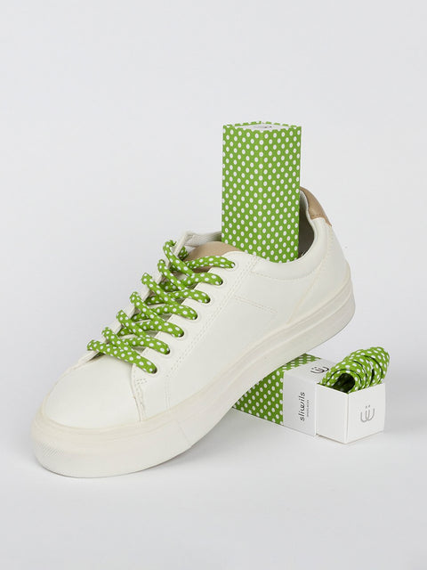 Zapatillas con cordones de lunares blancos sobre fondo verde claro