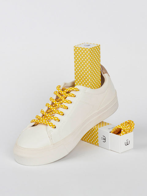 Bambas con cordones de lunares blancos sobre fondo amarillo