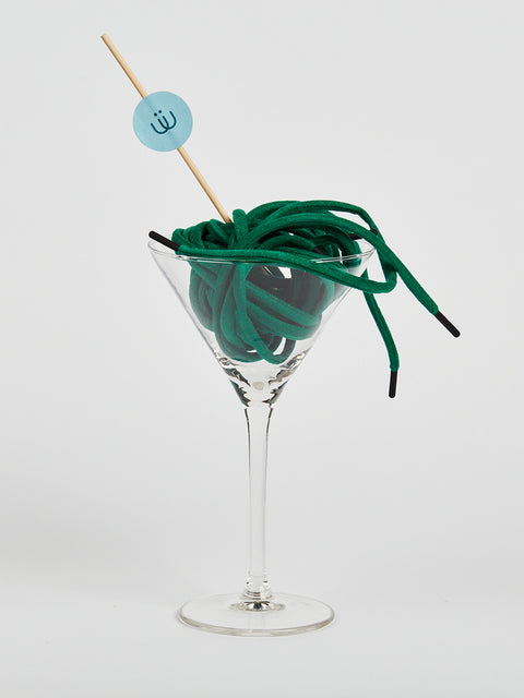 Cordón verde en antelina enrollado en una copa