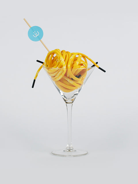 Cordón amarillo con estampado tie dye enrollado en una copa