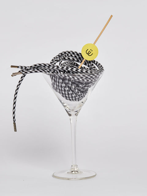 Cordón de cuadros vichy blanco y negro metido en una copa de cristal